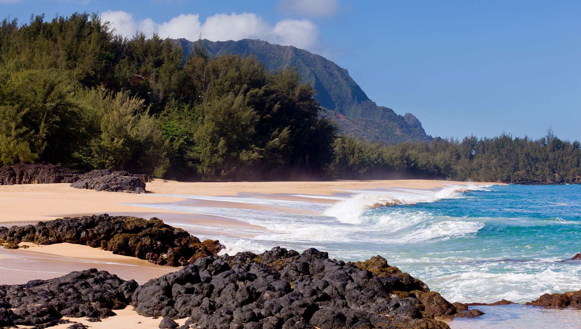 12451387 - waves crash onto lumahai beach on kauai hawaii with na pali coast