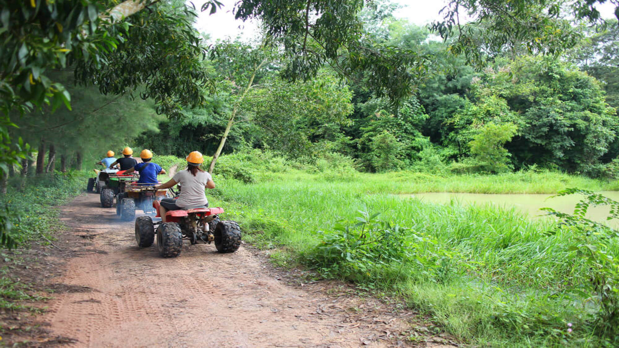 A group driving ATVs on a trail on a Kauai ATV tour