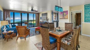 The dining room and living room in Poipu Makai have oceanfront views and access to the lanai