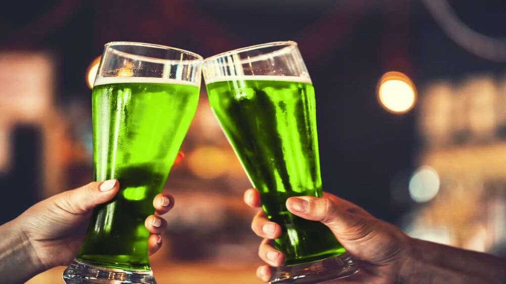 Friends raising glasses of green beer to celebrate St. Patrick's Day on Kauai, Hawaii