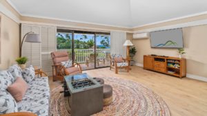 The living room with a seating area and television of Kiahuna Plantation 207