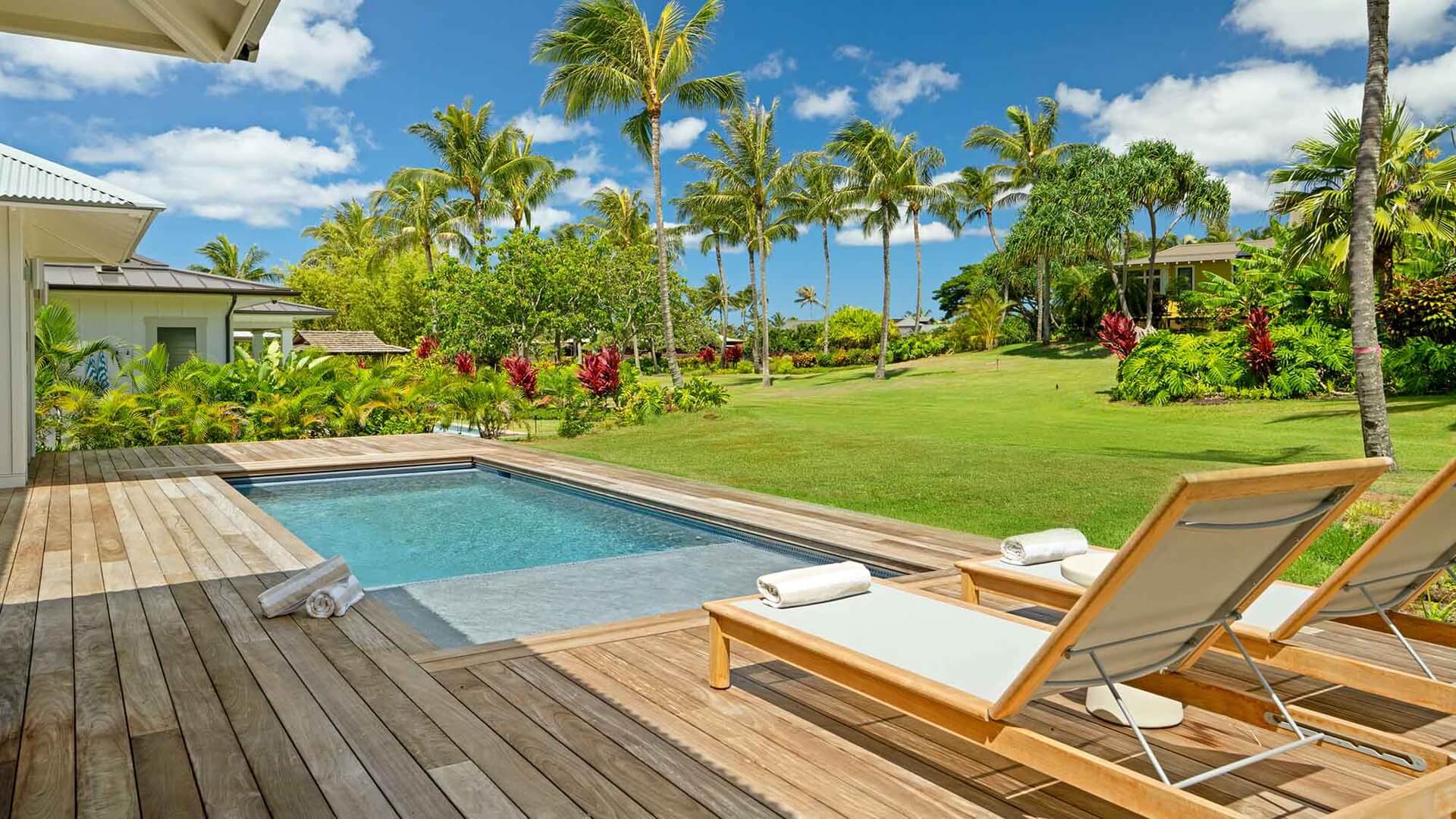 Lounge chairs overlooking a pool and garden views at Kukuiula Makai Cottage #22